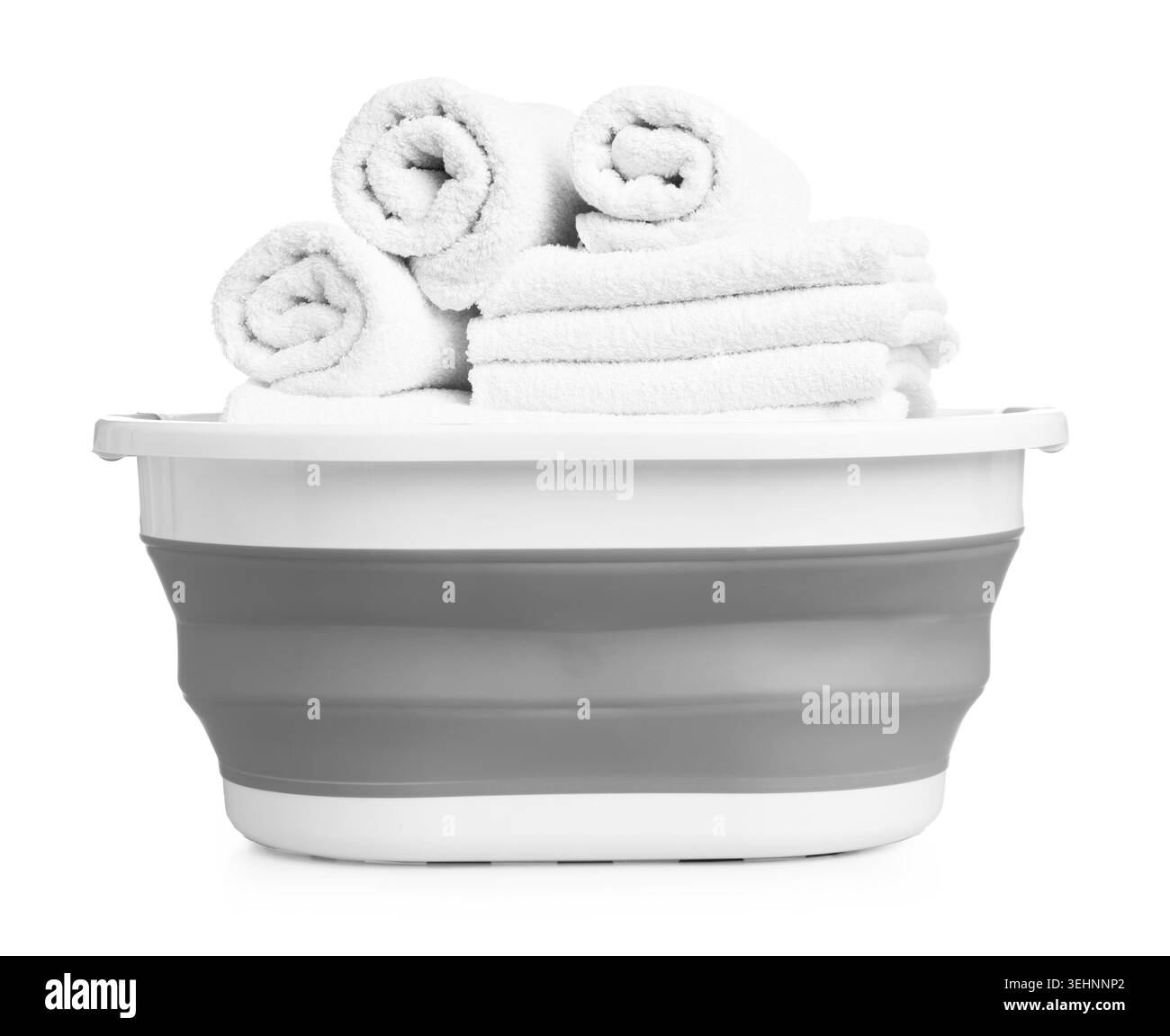 Beaucoup de serviettes propres douces dans le panier à linge isolé sur blanc Banque D'Images