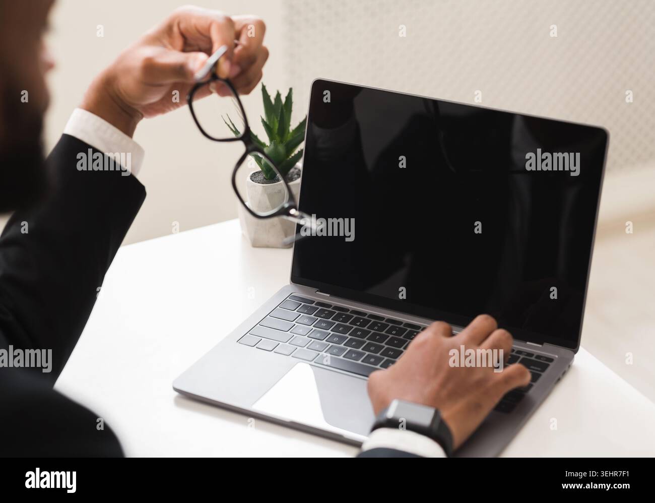 Image recadrée de l'homme d'affaires à l'aide d'un ordinateur portable avec écran vide Banque D'Images