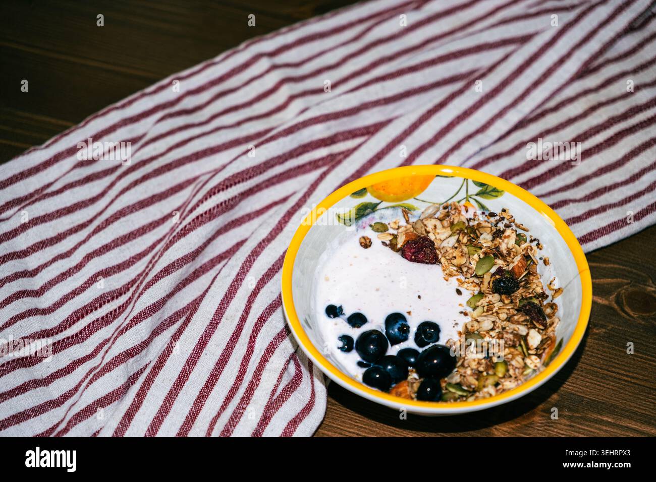 Bol à smoothie aux myrtilles sain avec granola et baies fraîches sur une table en bois rustique Banque D'Images