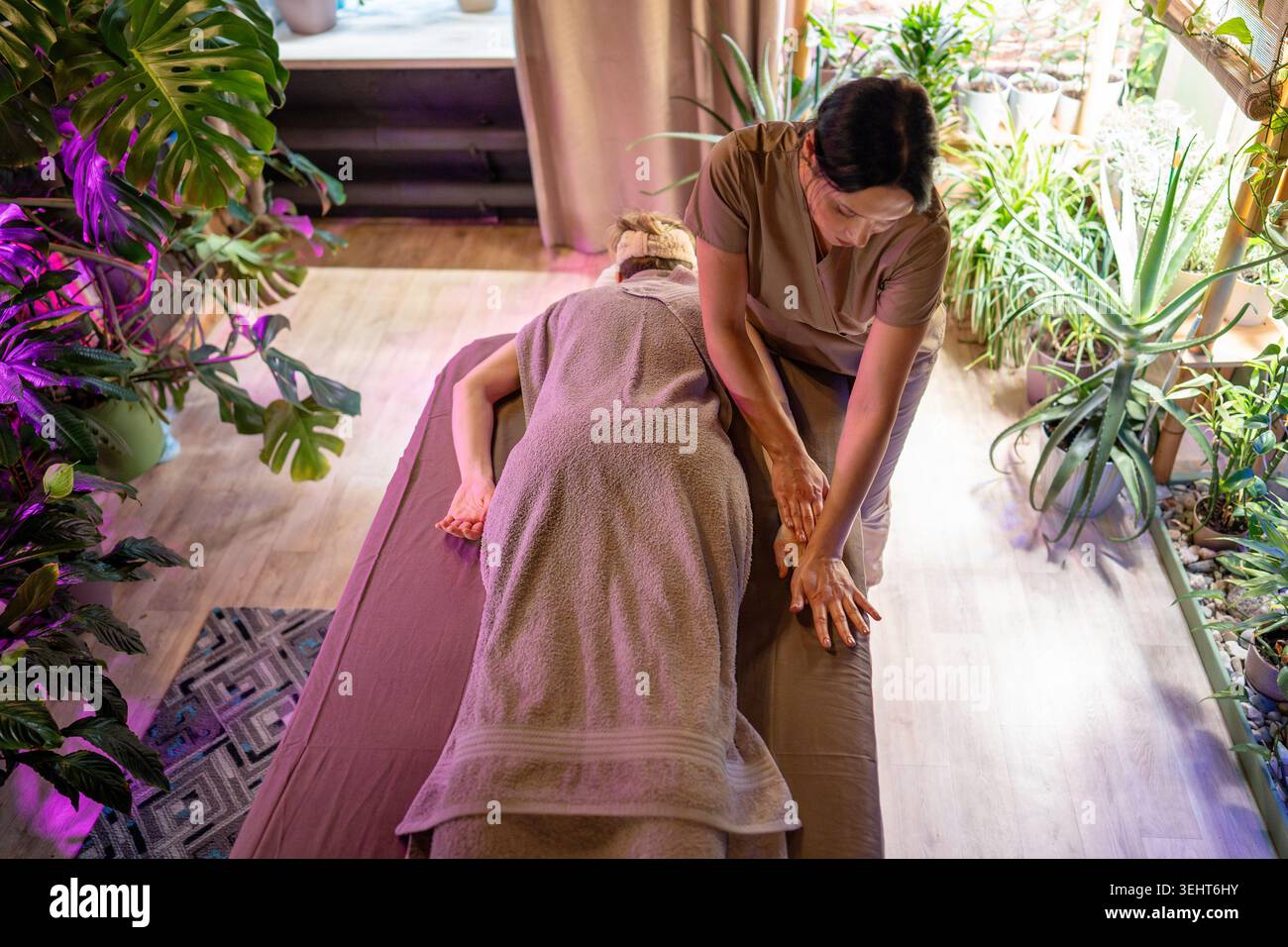 Femme client couché sur la table de spa dans le salon de beauté appréciant la thérapie de traitement de soin relaxant. Banque D'Images