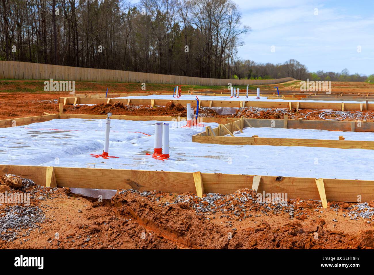 Les travailleurs préparent le terrain pour le nouveau bâtiment de dalle de fondation avec des tuyaux d'ossature en bois dans la zone de construction Banque D'Images