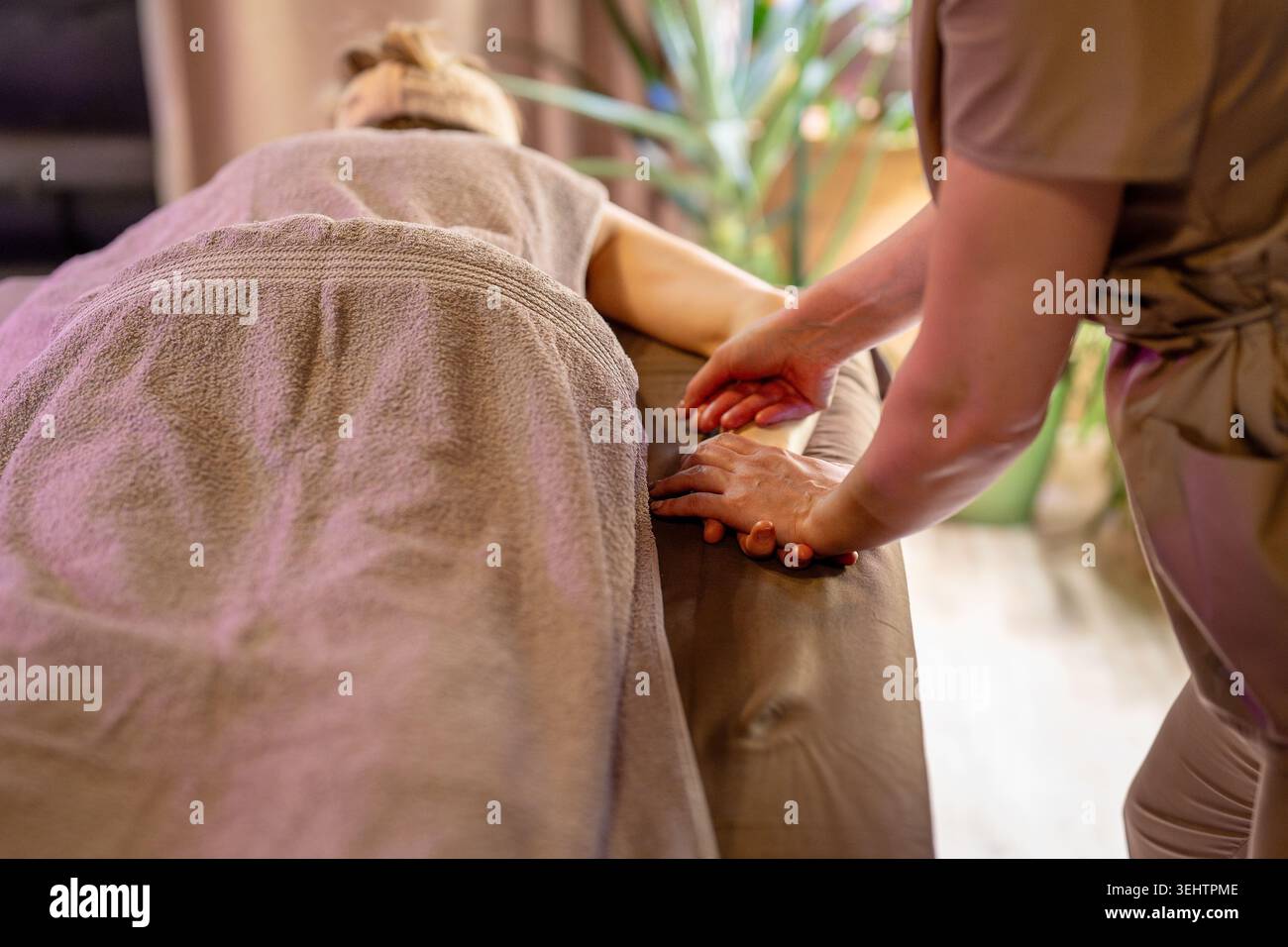 Séance de thérapie professionnelle en clinique de beauté, masseuse féminine spécialiste massant femme détendue. Banque D'Images