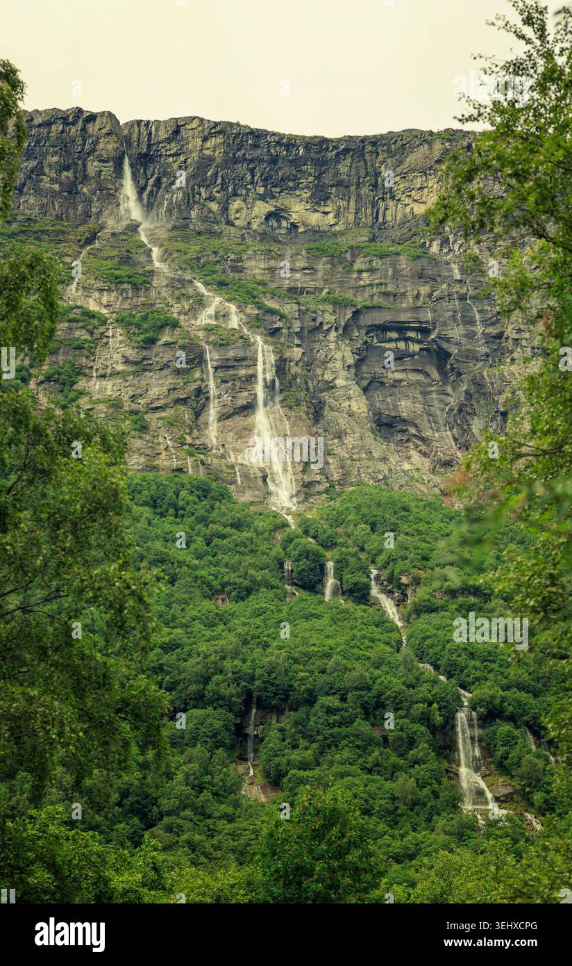 Skorga, Norvège - 22.05.2026 : une falaise accidentée avec plusieurs fines chutes d'eau blanches et une mousse verte luxuriante. Banque D'Images