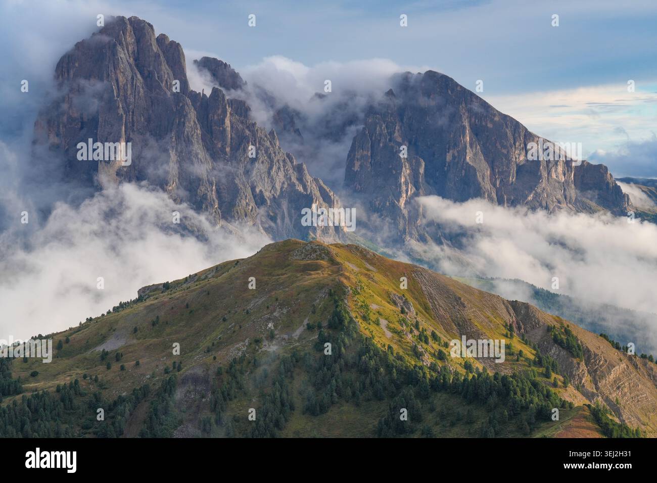 Chaîne de montagnes Langkofel enveloppée dans les nuages au beau coucher du soleil, Tyrol du Sud, Val Gardena, Dolomites, Italie. Banque D'Images