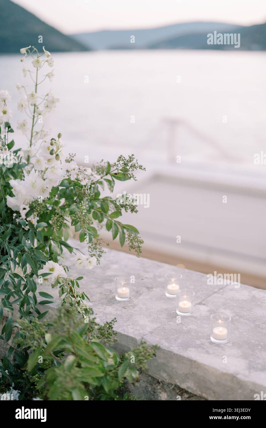 Bougies éthérées avec ambiance feuilletée. Cadre calme en soirée avec fleurs et chandelles Banque D'Images