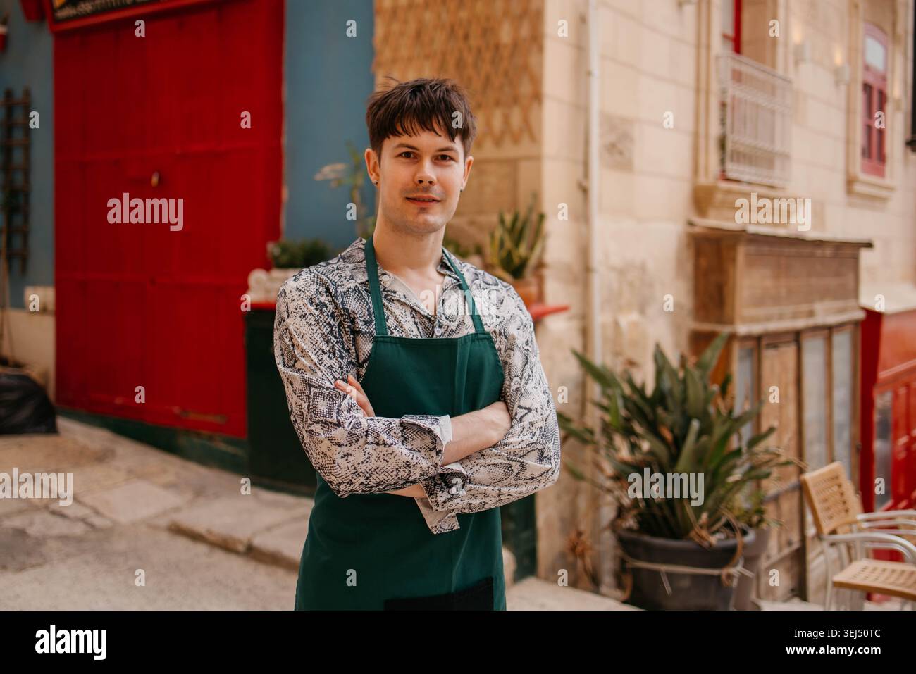 Un serveur est en train de ranger le jardin du café Banque D'Images