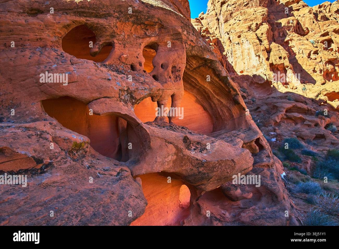 Sandstone Holes et Glowing Nook dans la formation ensoleillée Red Rock Desert Banque D'Images