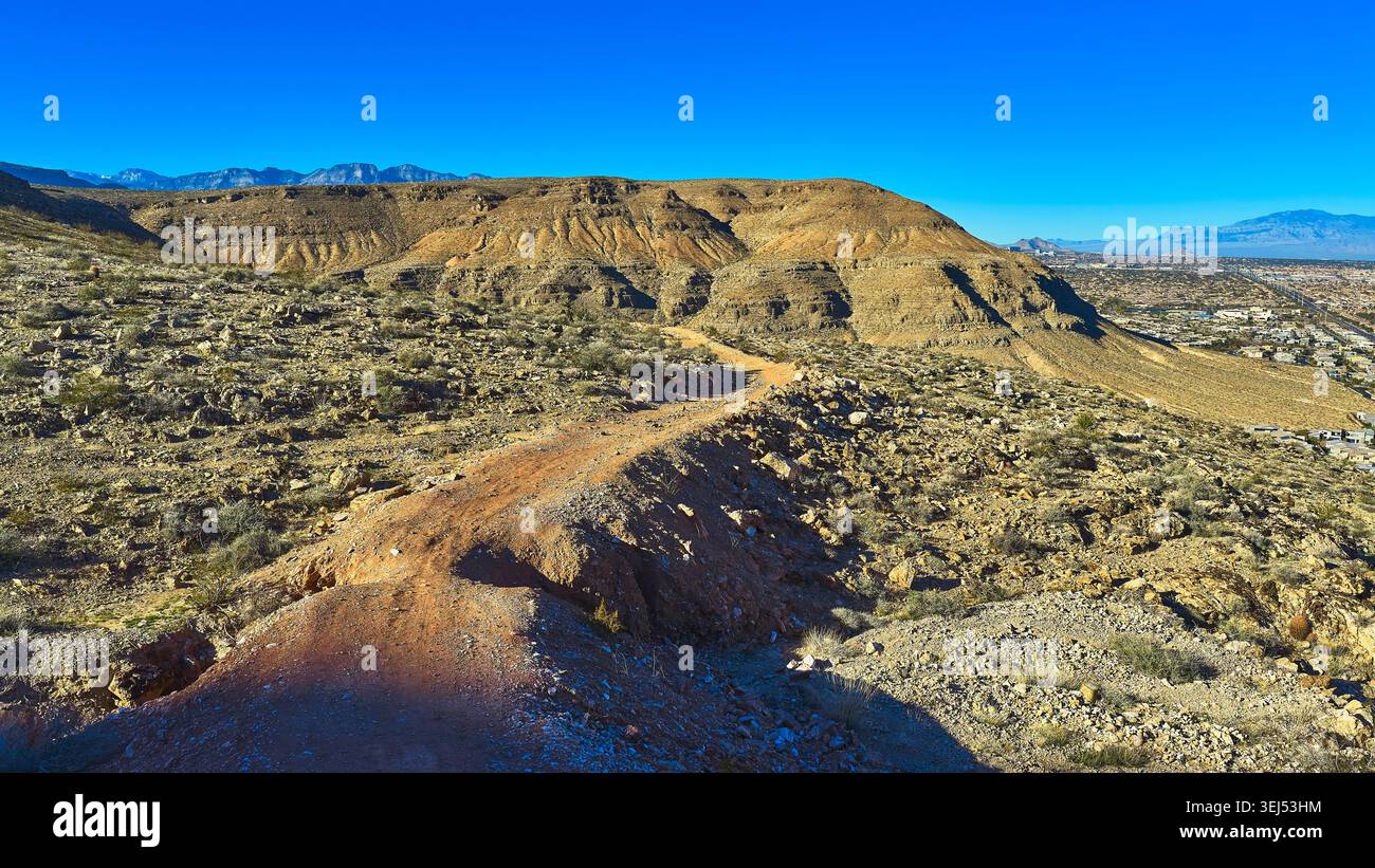 Desert Hills et Winding Road avec Las Vegas lointain sous Clear Blue Sky Banque D'Images