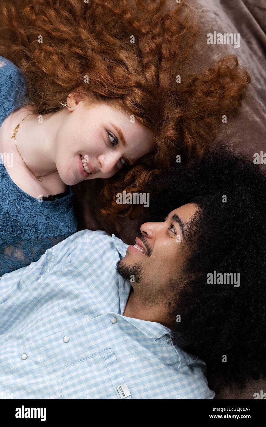 Jeune couple interracial heureux souriant et se regardant Banque D'Images