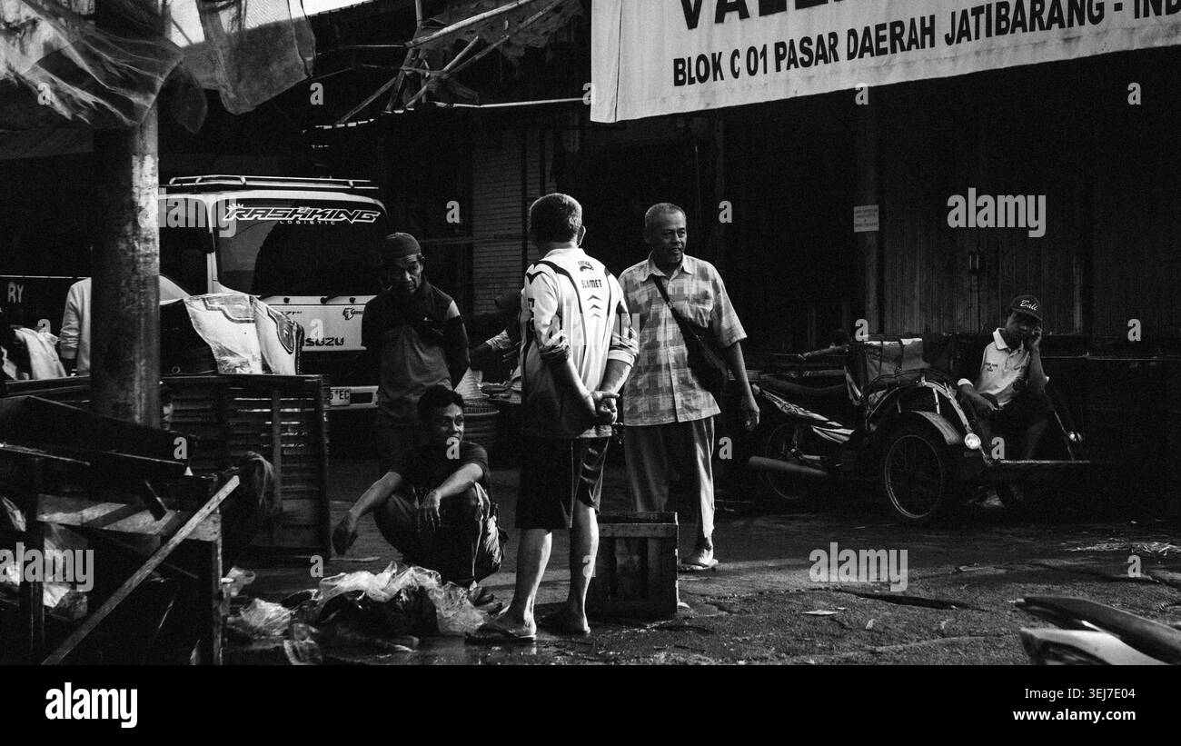 Un groupe d'hommes indonésiens locaux se rassemblent et conversent à l'extérieur d'un magasin à Pasar Daerah Jatibarang (marché régional de Jatibarang) Banque D'Images
