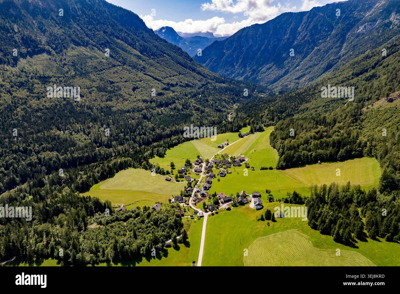 Vue aérienne du village alpin dans la vallée de montagne, Autriche. Prise de vue aérienne époustouflante par drone d'un petit village traditionnel aux champs verdoyants nichés Banque D'Images