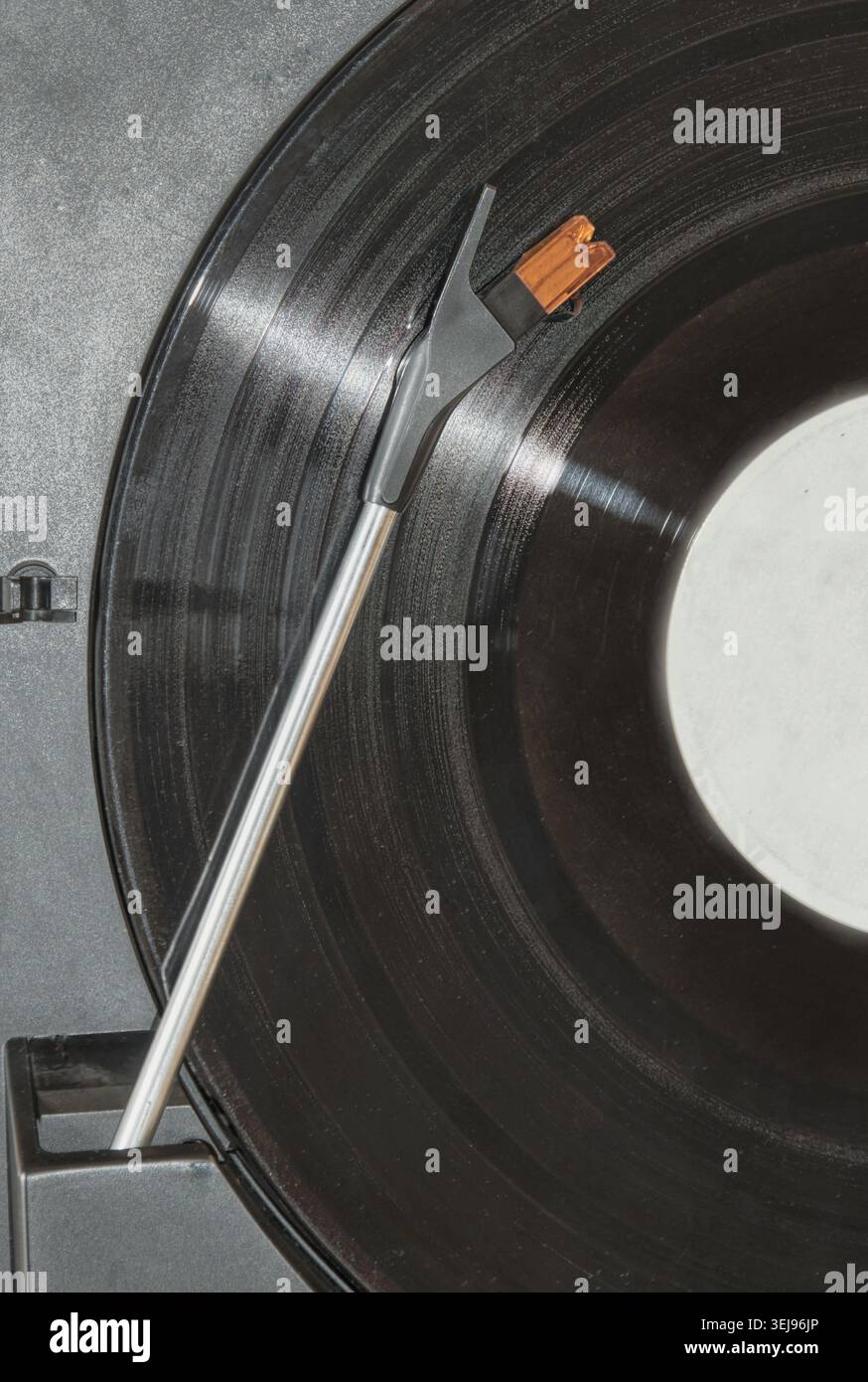 Gros plan d'un disque vinyle jouant sur une platine avec l'aiguille du stylet reposant dans les rainures. Banque D'Images