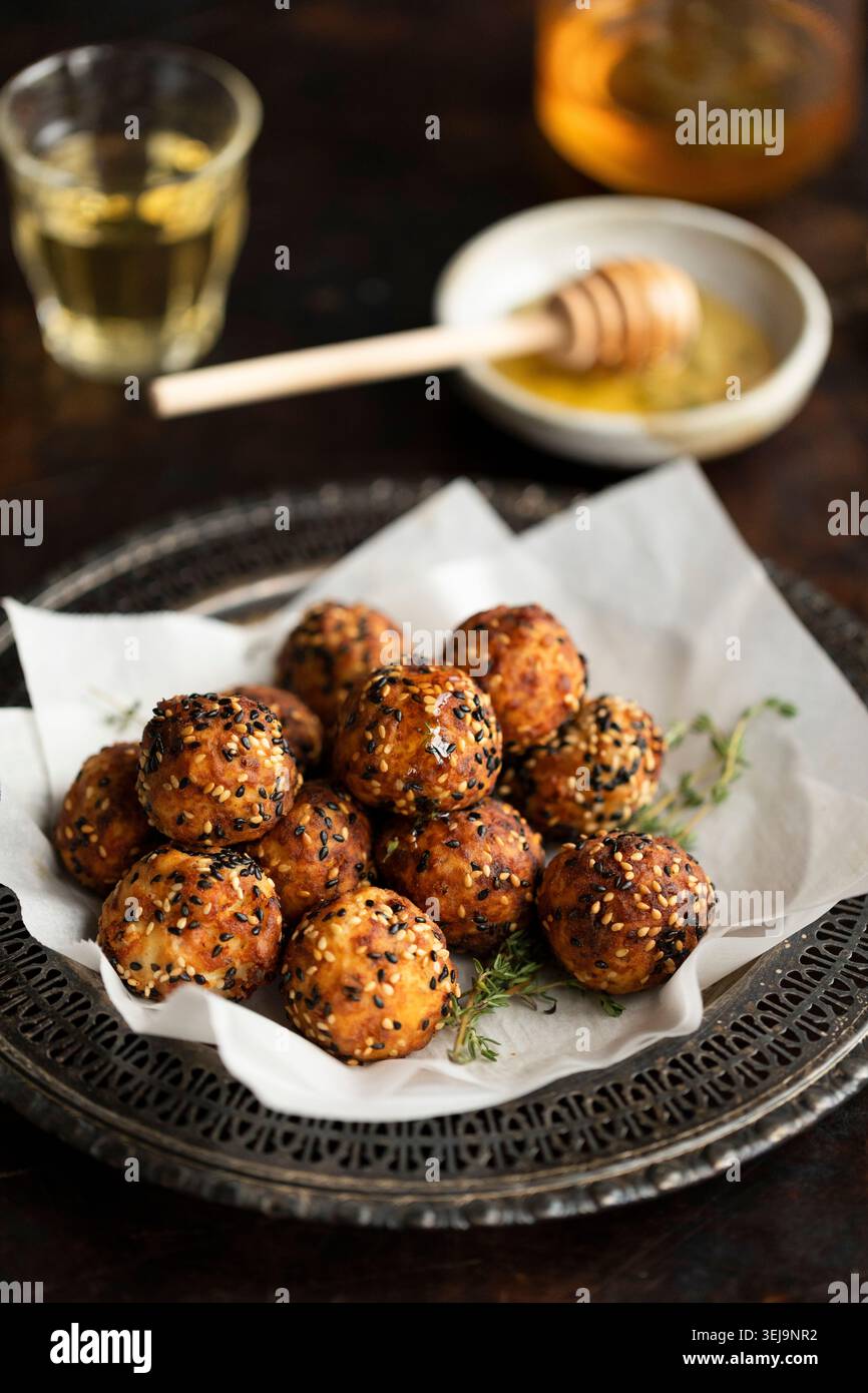 Boules de feta crétoise avec miel et sésame sur assiette rustique Banque D'Images