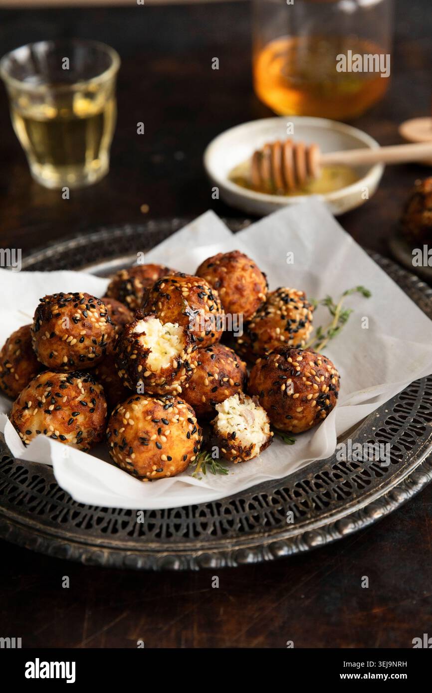 Boules de feta crétoise avec miel et sésame sur assiette rustique Banque D'Images