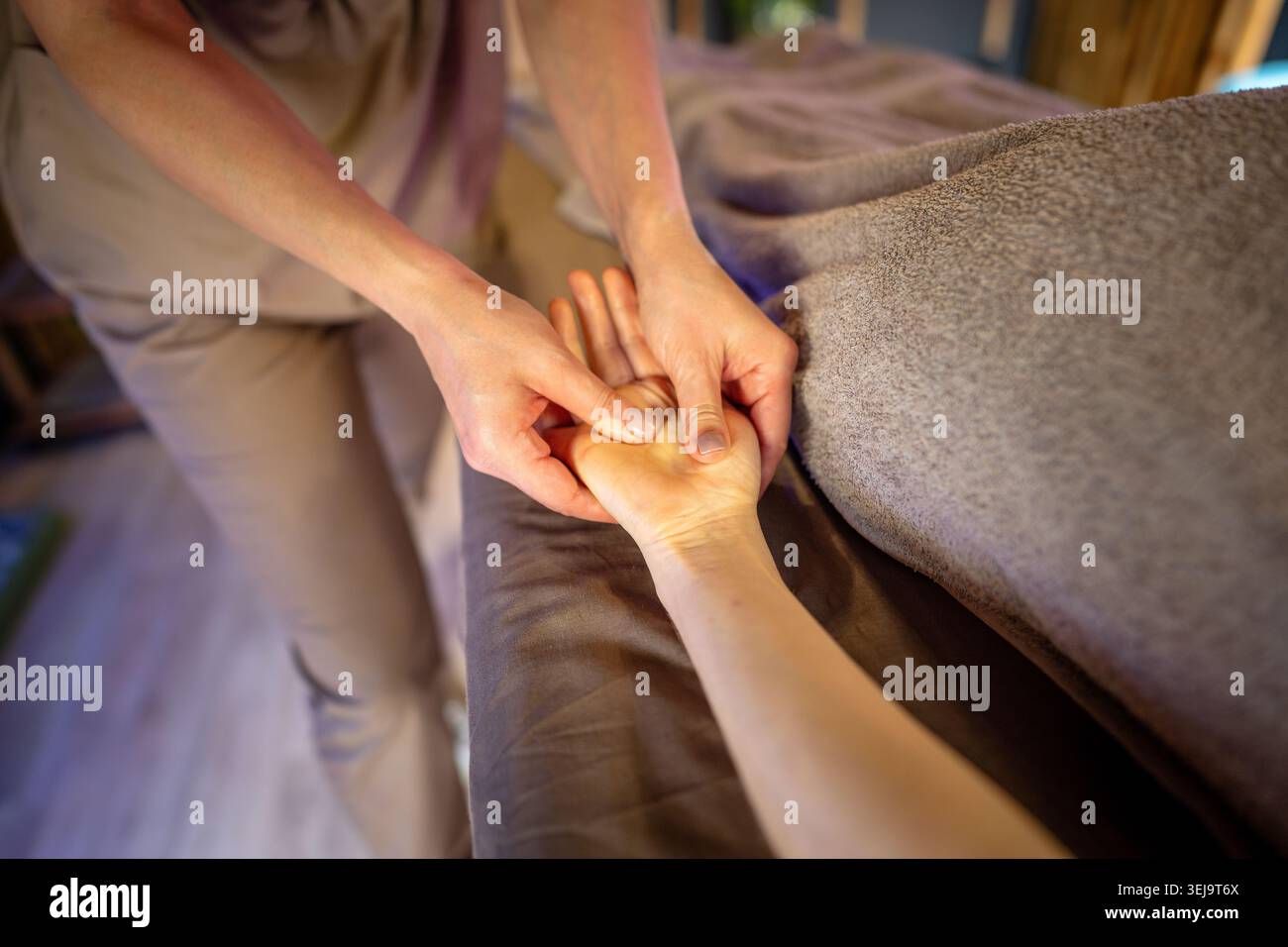 Soin de massage de guérison, masseuse professionnelle spécialiste de la femme massant le bras patient de la femme. Banque D'Images