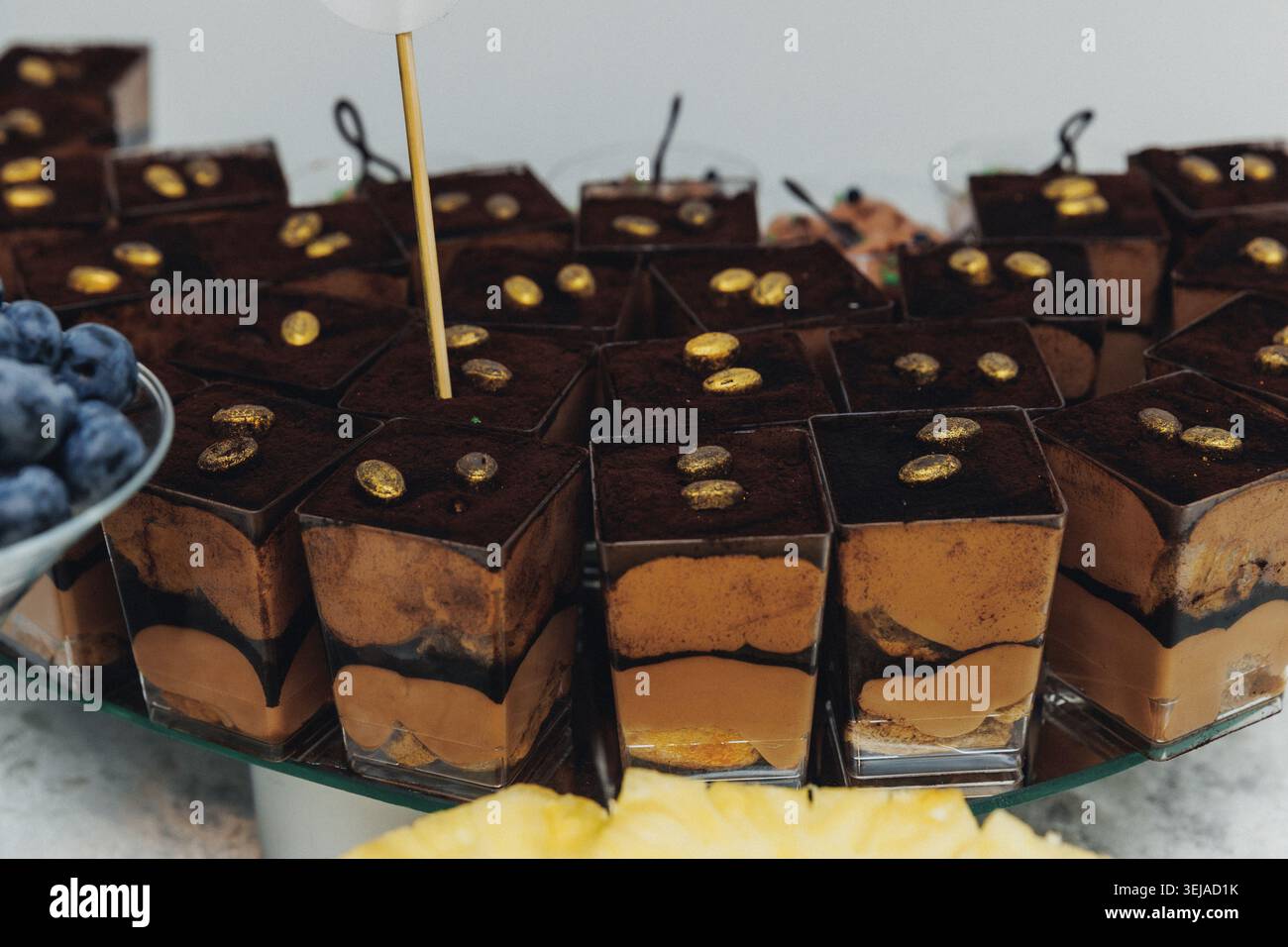 Cubes de chocolat avec garniture dorée, soigneusement disposés sur verre Banque D'Images