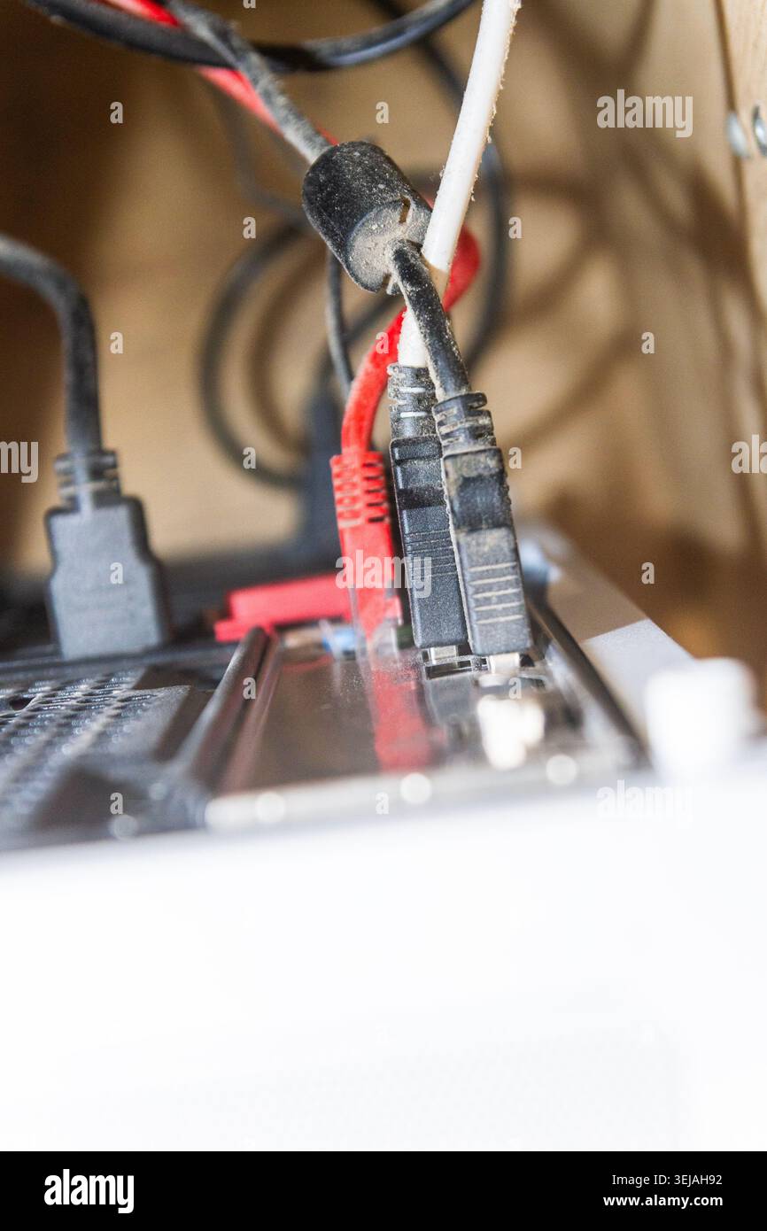 Gros plan des câbles réseau et USB poussiéreux connectés au panneau arrière de l'ordinateur Banque D'Images