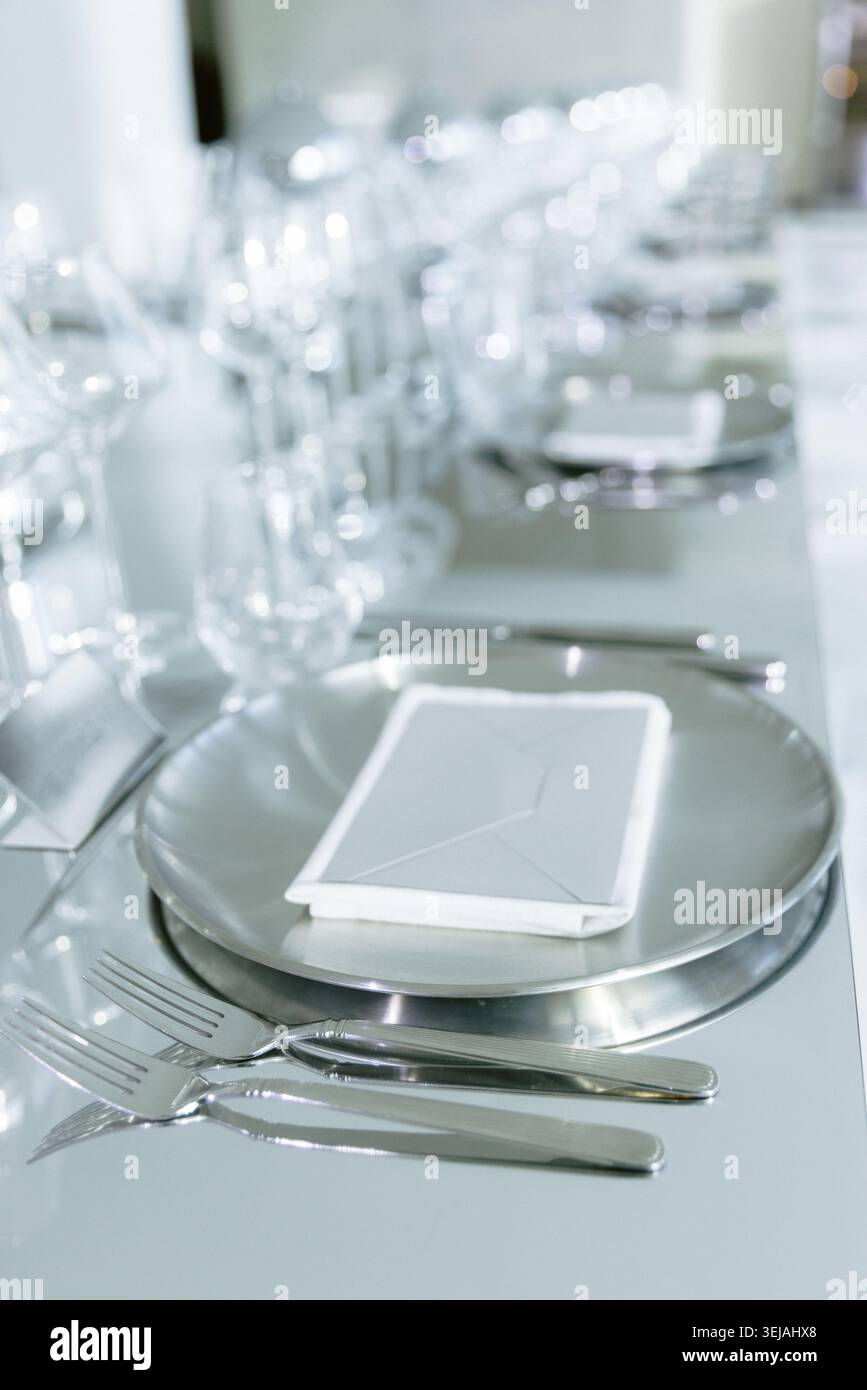Table de restaurant élégante avec assiettes blanches et verres en cristal Banque D'Images