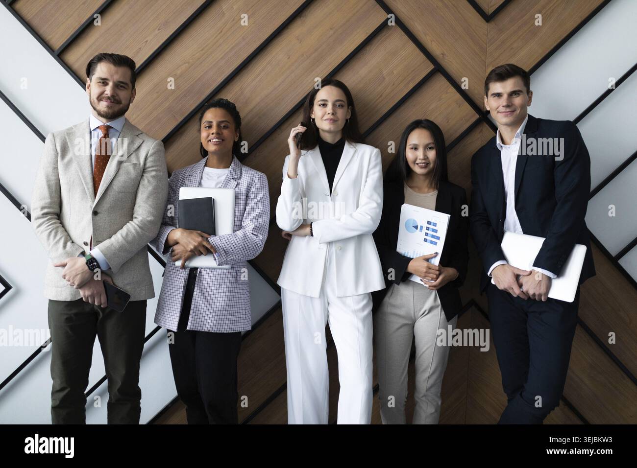 Portrait d'une équipe d'affaires créative réussie regardant la caméra et souriant. Des gens d'affaires divers debout ensemble au démarrage Banque D'Images