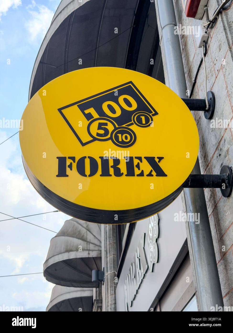 Signe Forex rond jaune pour le change de devises monté sur une façade de bâtiment de ville Banque D'Images