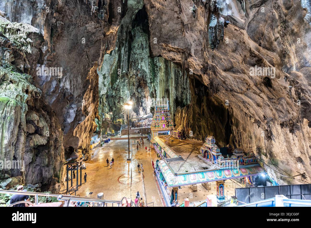Vue en hauteur des sanctuaires hindous colorés et des visiteurs sous un immense plafond de calcaire dans la grotte cathédrale des grottes de Batu à Kuala Lumpur, Malaisie Banque D'Images