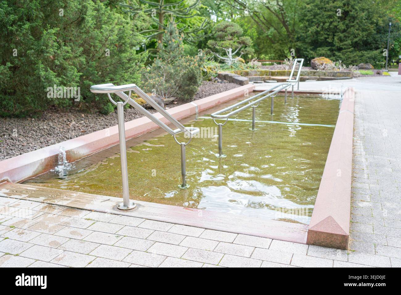 Une piscine extérieure Kneipp Water Cure Therapy pour les soins de bien-être des pieds marchant dans un magnifique parc thermal verdoyant. Construction en béton remplie Banque D'Images