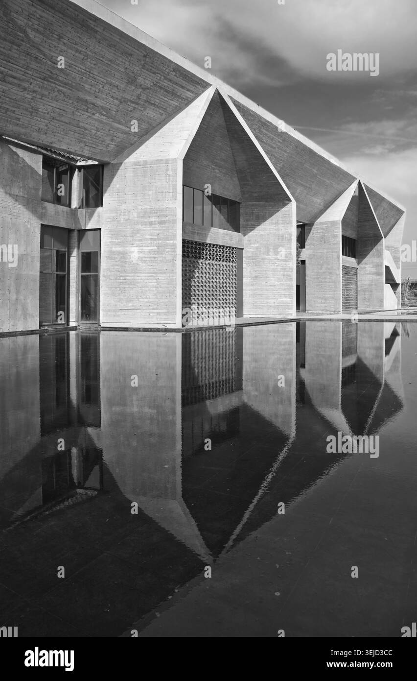 Architecture brutaliste en béton avec de fortes lignes géométriques et une symétrie réfléchissante de l'eau. Banque D'Images