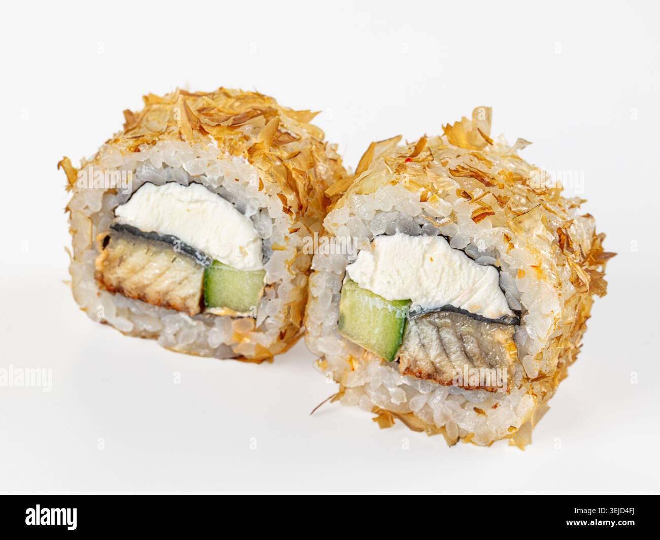 Gros plan de deux rouleaux de sushi uramaki japonais avec anguille, fromage à la crème et concombre, recouverts de flocons de bonite. Plan studio propre isolé sur un bac blanc Banque D'Images