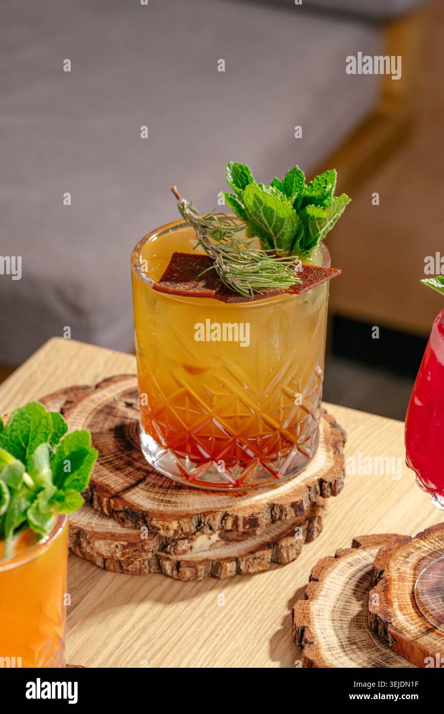 Cocktail artisanal de couleur ambre avec garniture d'herbes fraîches Banque D'Images