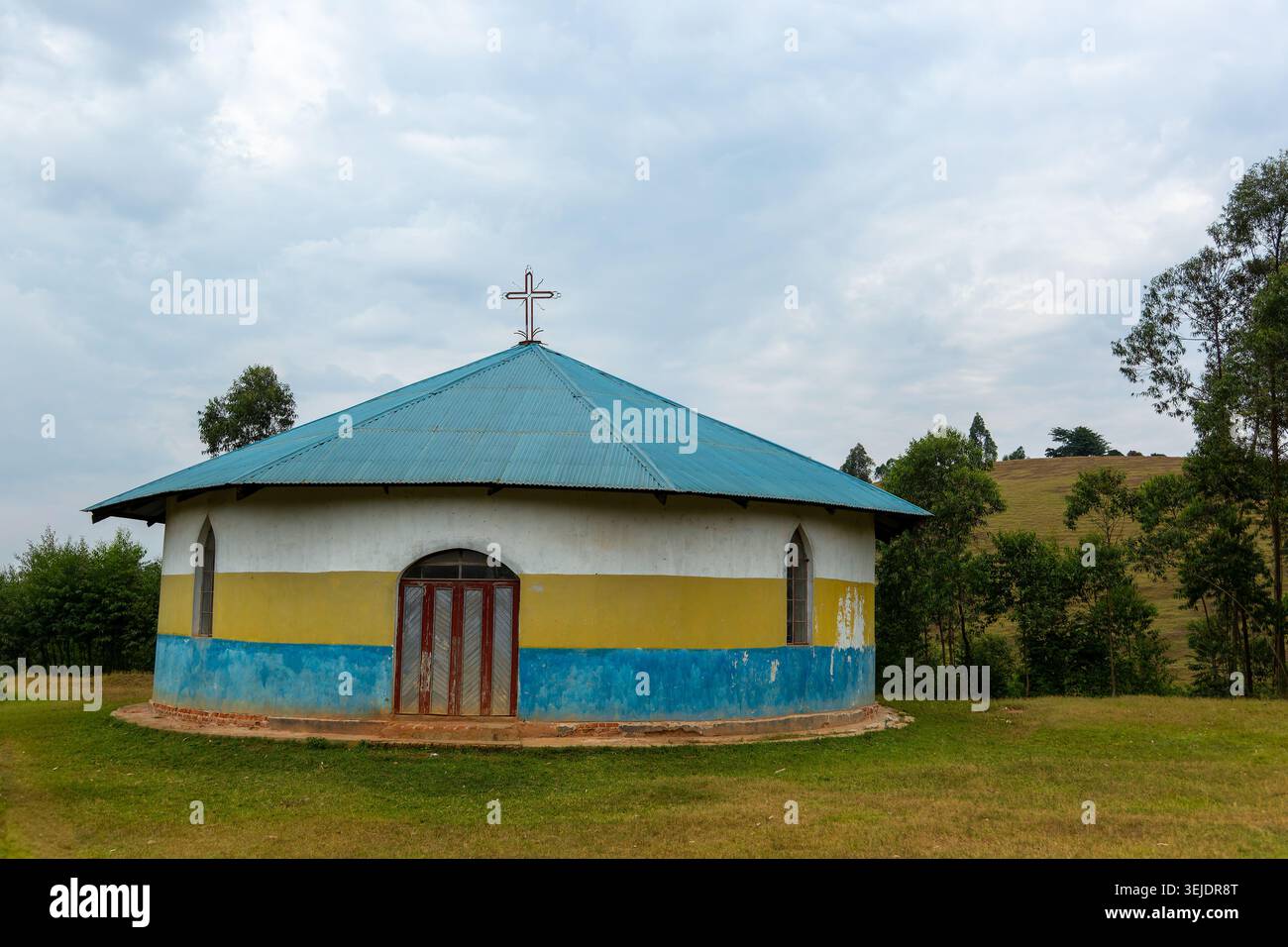 SACRÉ COEUR DE JÉSUS EGLISE CATHOLIQUE KANYAMBAARE HIIKA KYAMUHUNGA PAROISSE rurale ougandaise avec toit ondulé bleu et peint jaune blanc faca Banque D'Images