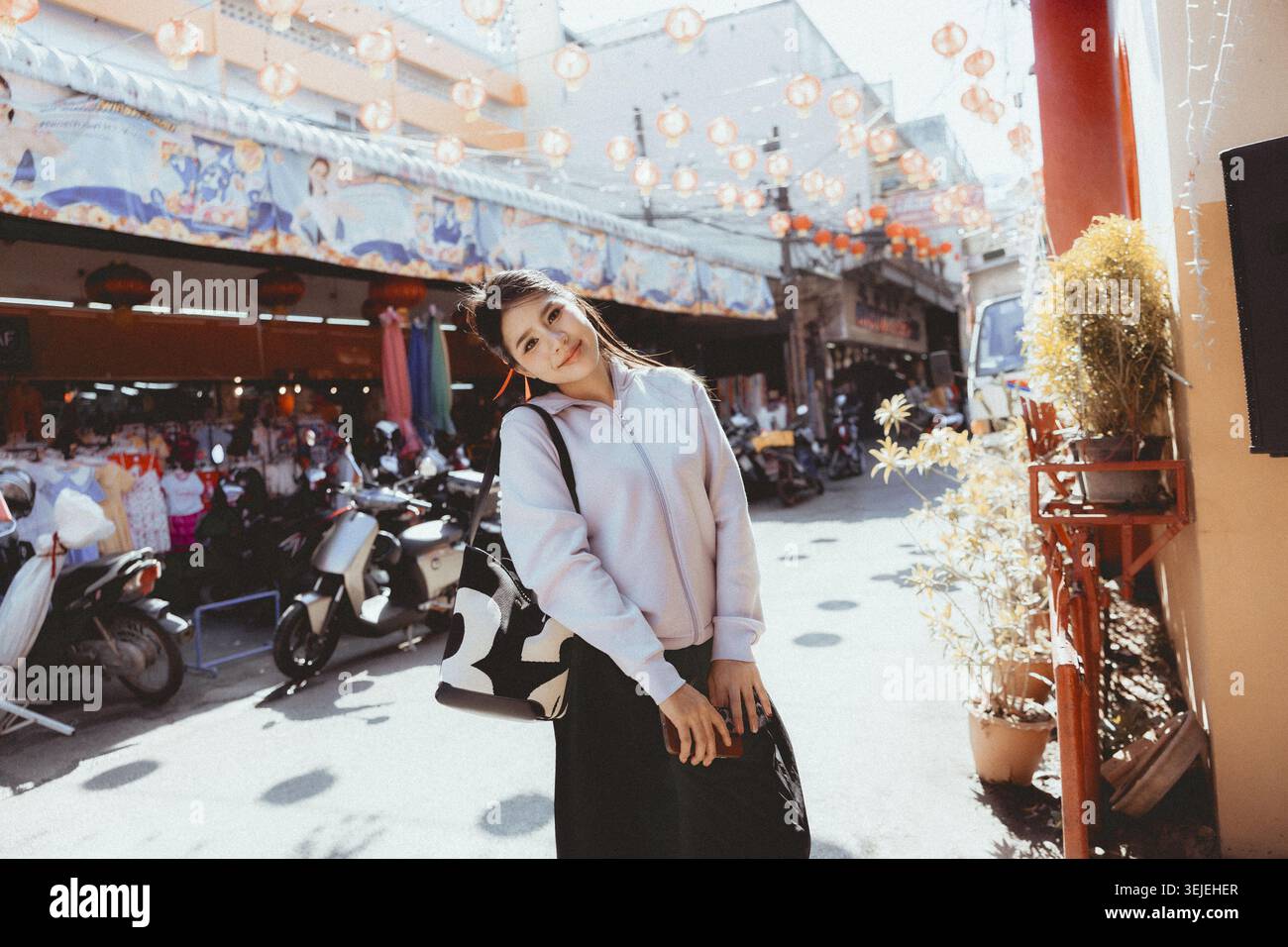 Heureuse jeune femme asiatique souriant sur la rue animée de la ville. belle touriste féminine appréciant son style de vie de voyage en plein air dans la ville urbaine historique avec cha Banque D'Images