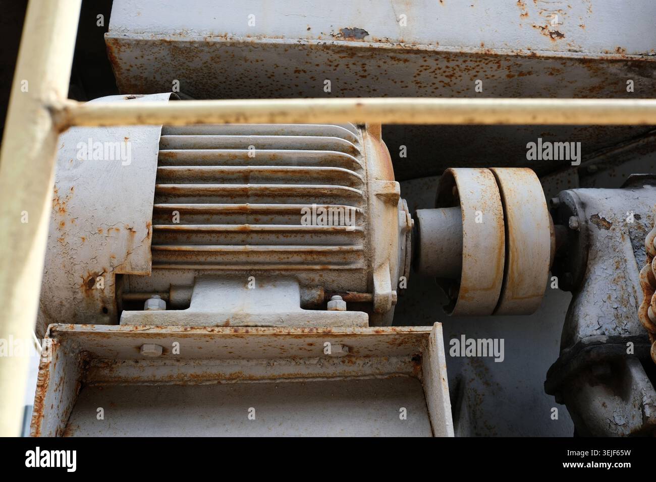 Un moteur électrique montre des signes d'âge et d'usure dans un environnement d'atelier poussiéreux. Banque D'Images