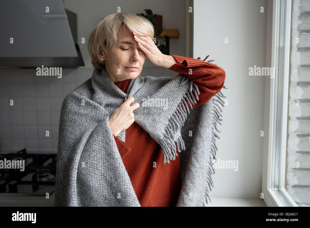 Femme d'âge moyen souffrant de haute température et de migraine lourde, problèmes de santé saisonniers. Banque D'Images