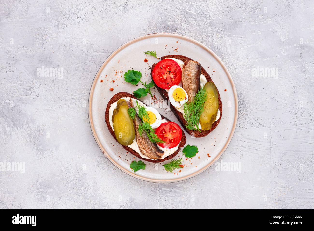 Sandwichs sur pain de seigle, avec sprats, œufs de caille, tomates fraîches et concombre mariné, apéritif, petit déjeuner, fait maison, Banque D'Images