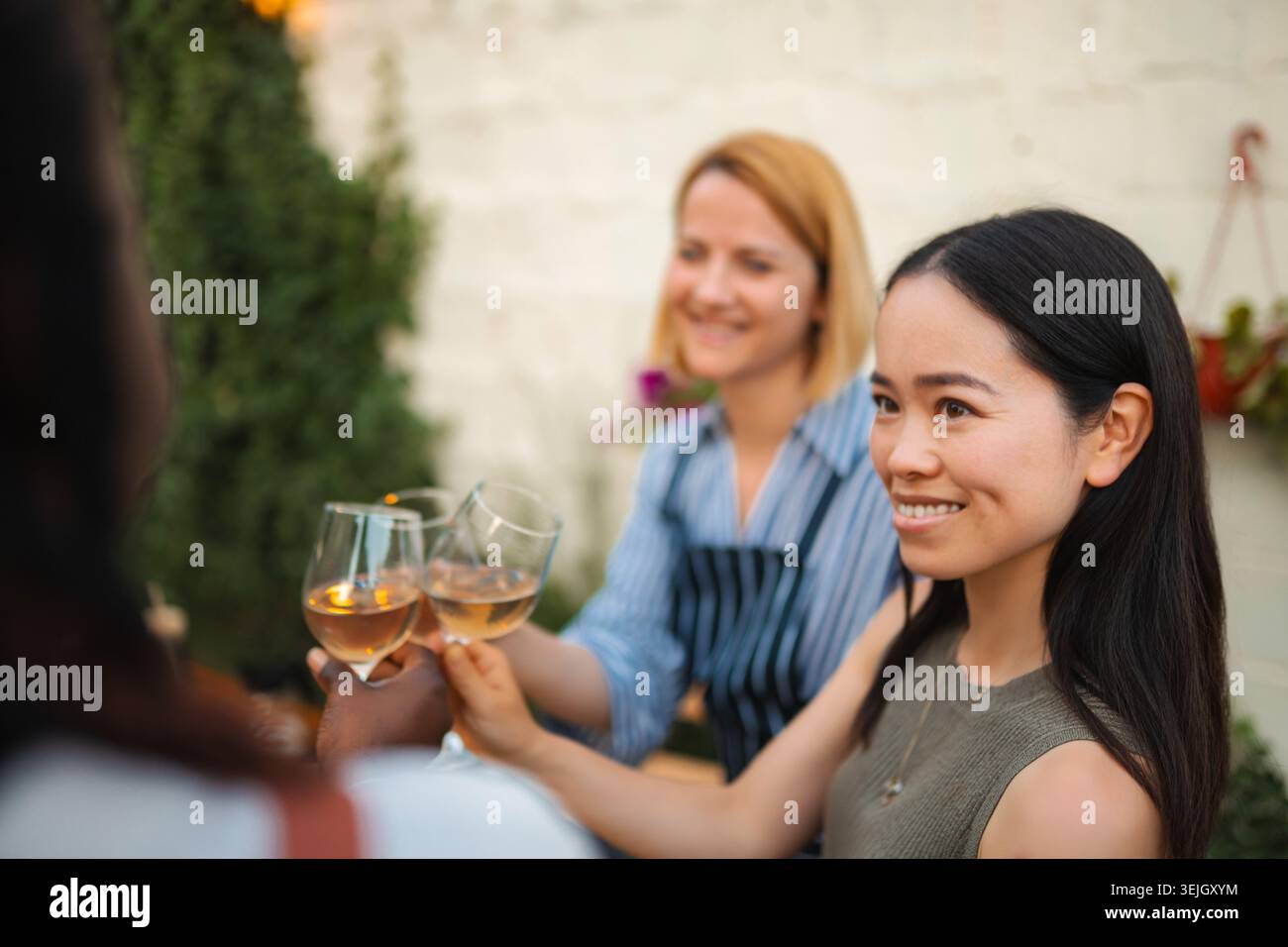Amis femmes multi ethniques toast avec du vin rose Banque D'Images