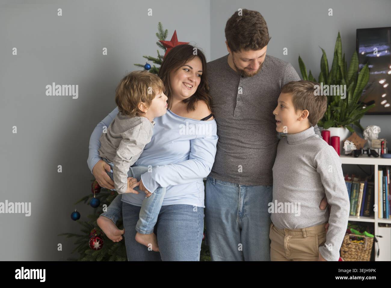 Famille maman, papa et deux enfants frères le matin de Noël à la maison. Banque D'Images