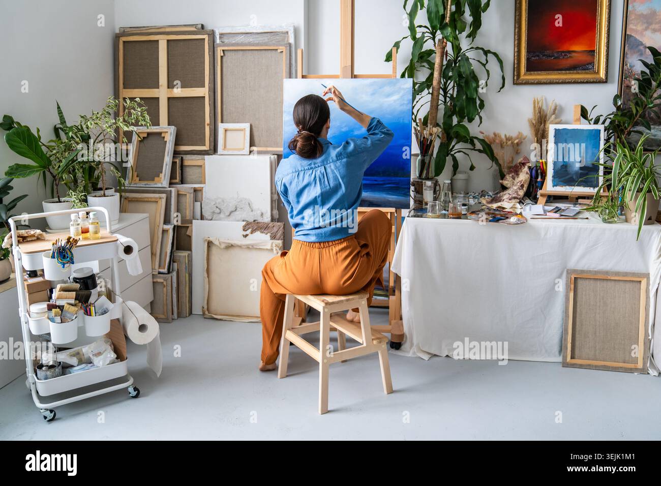Artiste femme talentueuse travaillant sur un nouveau chef-d'œuvre à la maison atelier, appréciant l'art passe-temps au studio loft Banque D'Images
