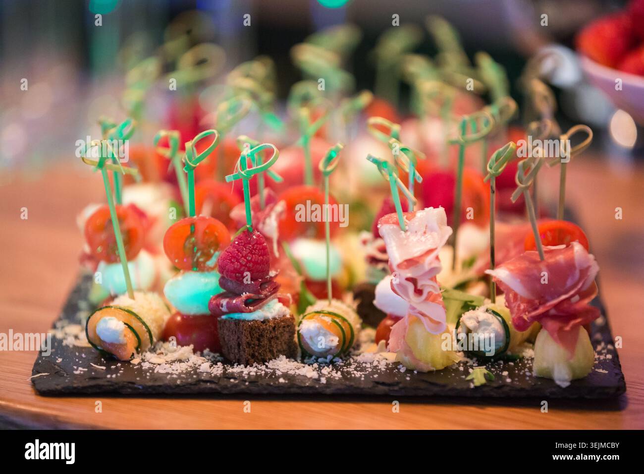 Assortiment de canapés avec bacon, fromage, tomates et pain noir à bord Banque D'Images