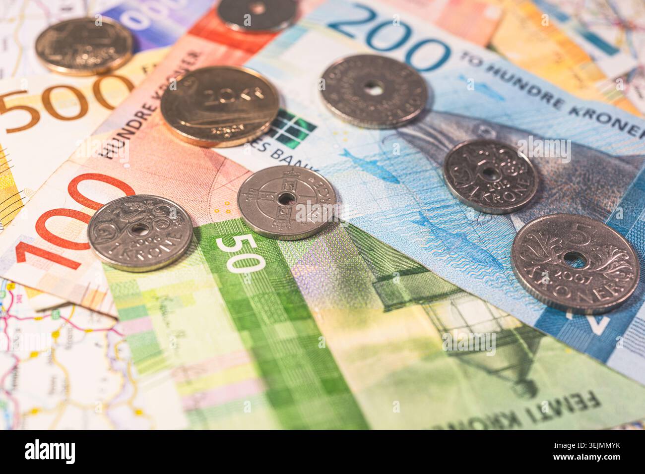 Monnaie scandinave billets et pièces de monnaie norvégiennes en couronnes norvégiennes sur la carte de voyage représentant l'économie et le tourisme Banque D'Images