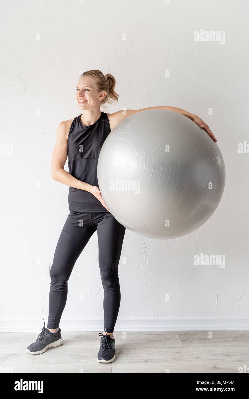 Portrait d'une jeune femme en forme tenant le fitball Banque D'Images