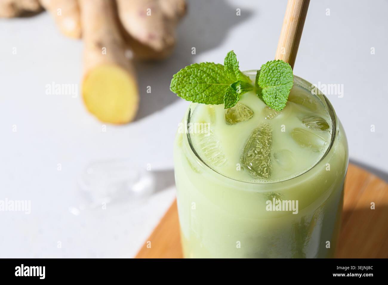 Thé vert glacé au matcha latte sur une table blanche. Gros plan. Banque D'Images