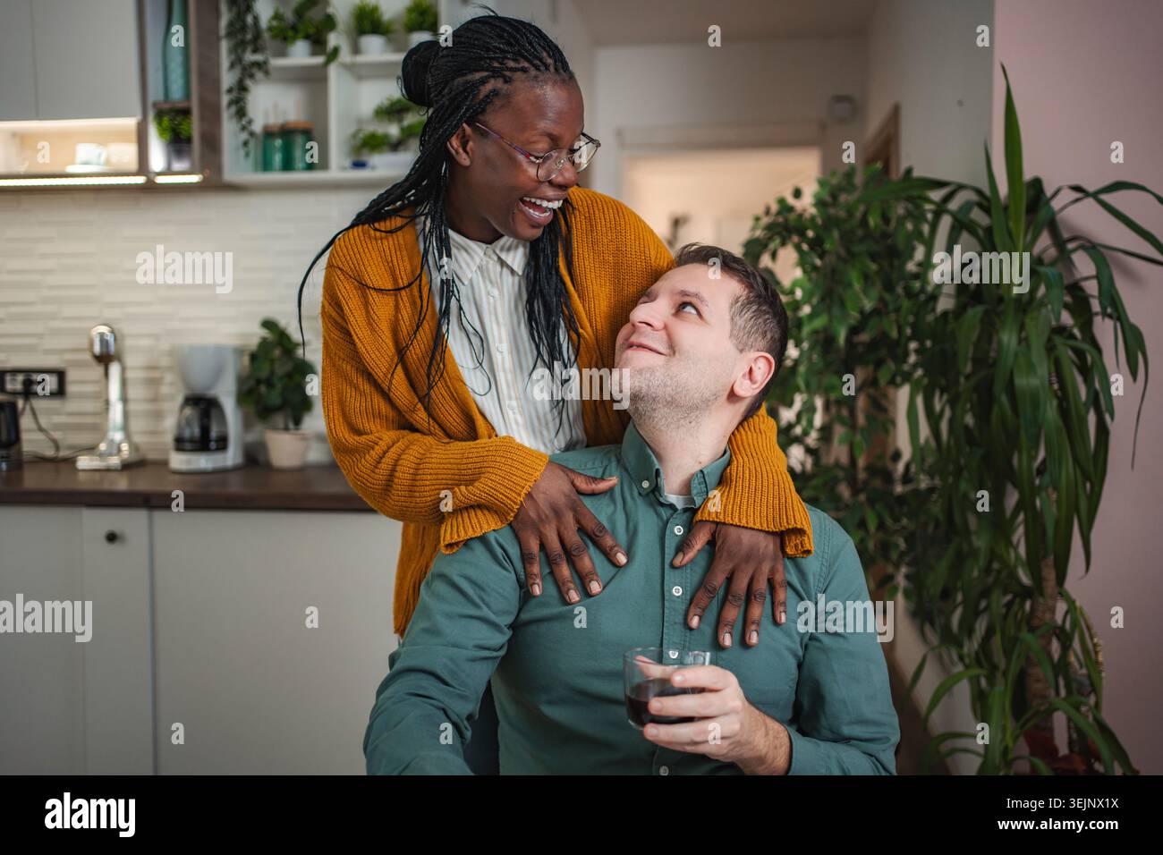 Couple interracial partageant un moment d'amour tendre dans la cuisine Banque D'Images