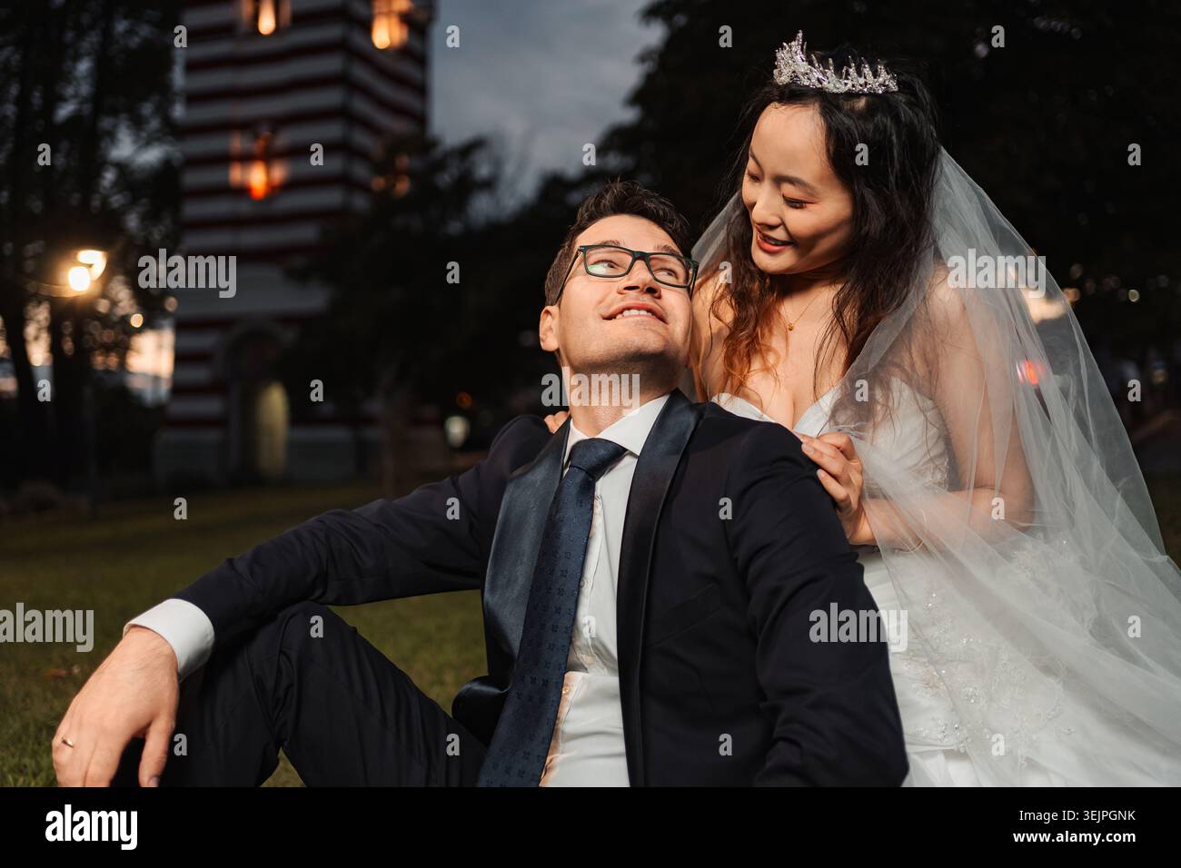 Couple interracial célébrant mariage dans le parc pendant la soirée Banque D'Images