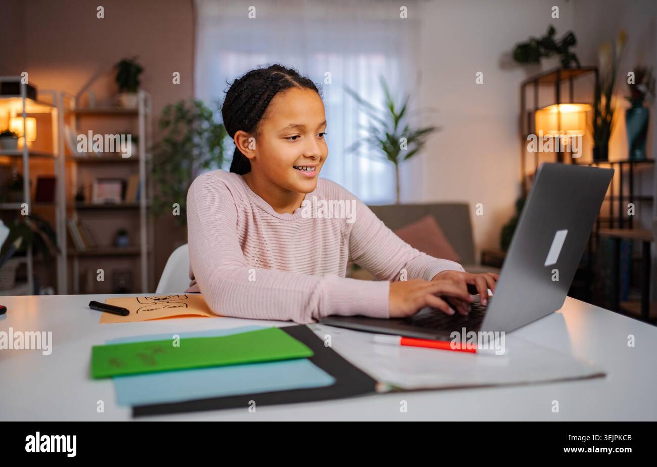 Écolière faisant de l'apprentissage à distance de la maison à l'aide d'un ordinateur portable Banque D'Images
