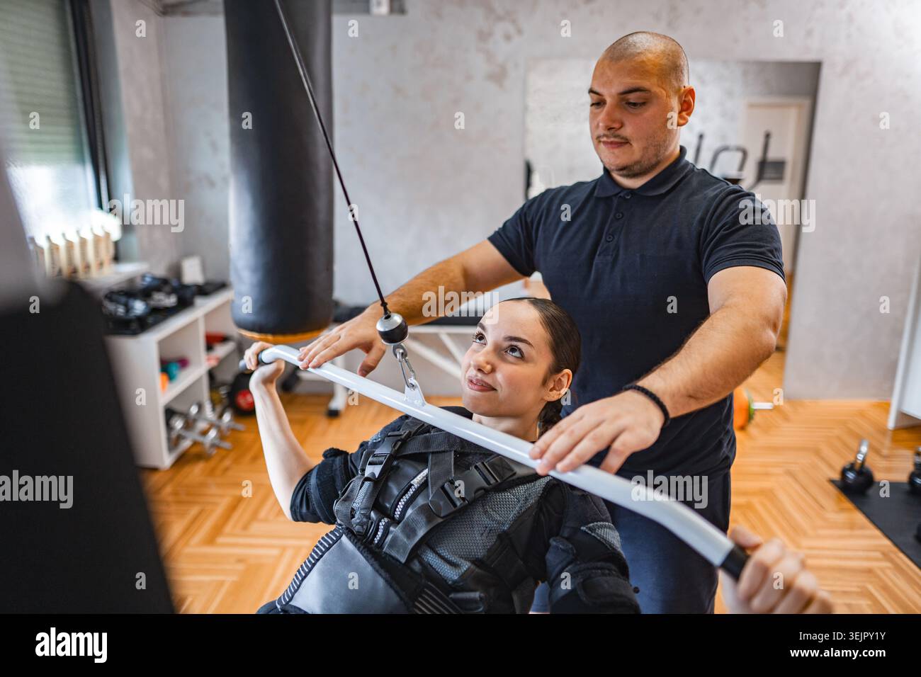 Séance d'entraînement avec équipement de stimulation musculaire en salle de gym Banque D'Images