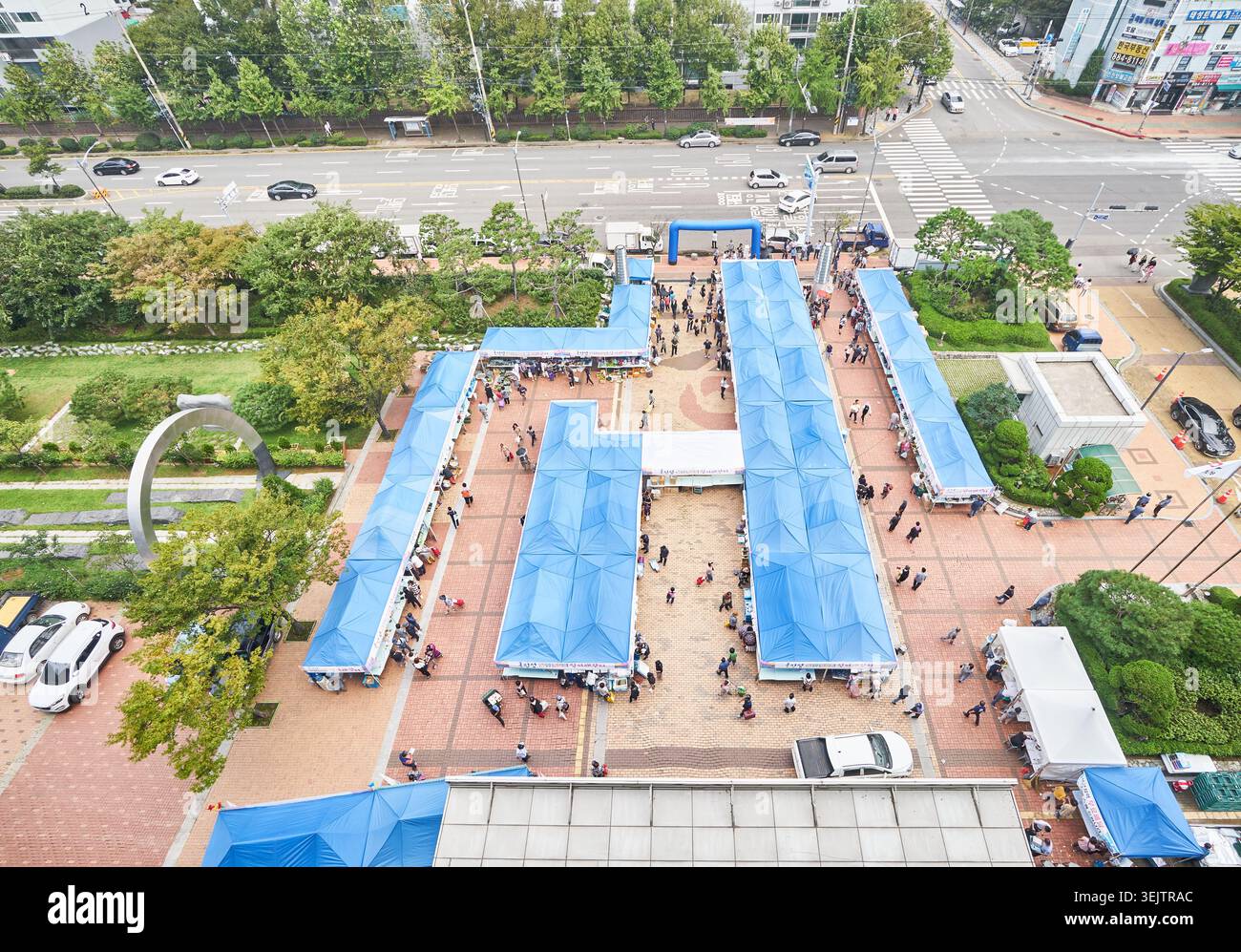 Ce cliché à grand angle capture un marché d'automne en plein air à Ongjin Gun. Les cabines bleues attirent les visiteurs à la recherche de produits locaux spécialisés dans une place. Banque D'Images