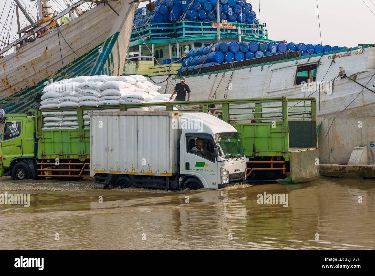 Chargement de fret domestique sur des bateaux traditionnels Pinisi pendant les inondations à Jakarta Banque D'Images