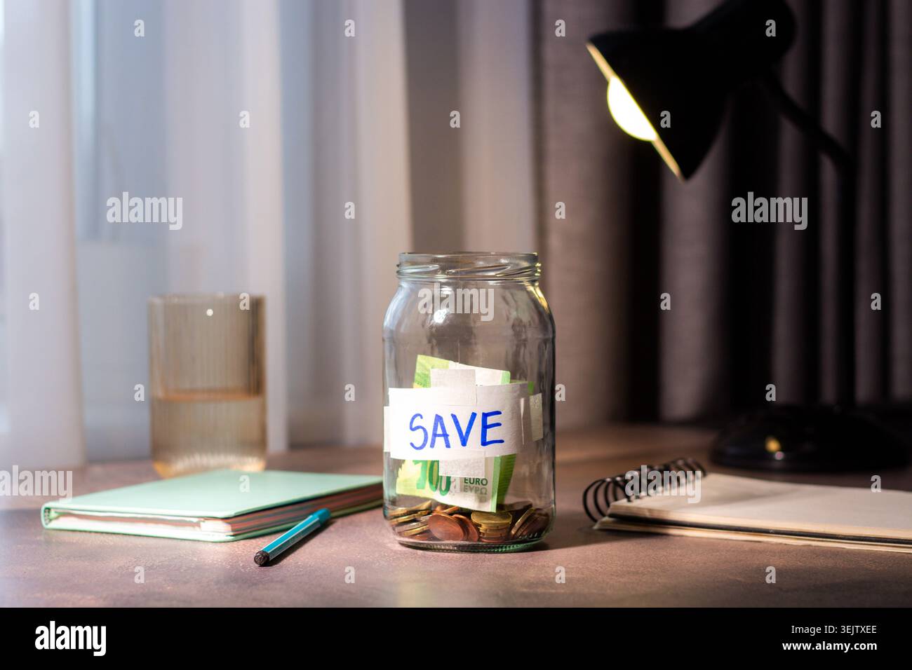 Gros plan du pot d'argent transparent. Représente les méthodes d'épargne traditionnelles et la gestion consciente de l'argent pour la sécurité future Banque D'Images