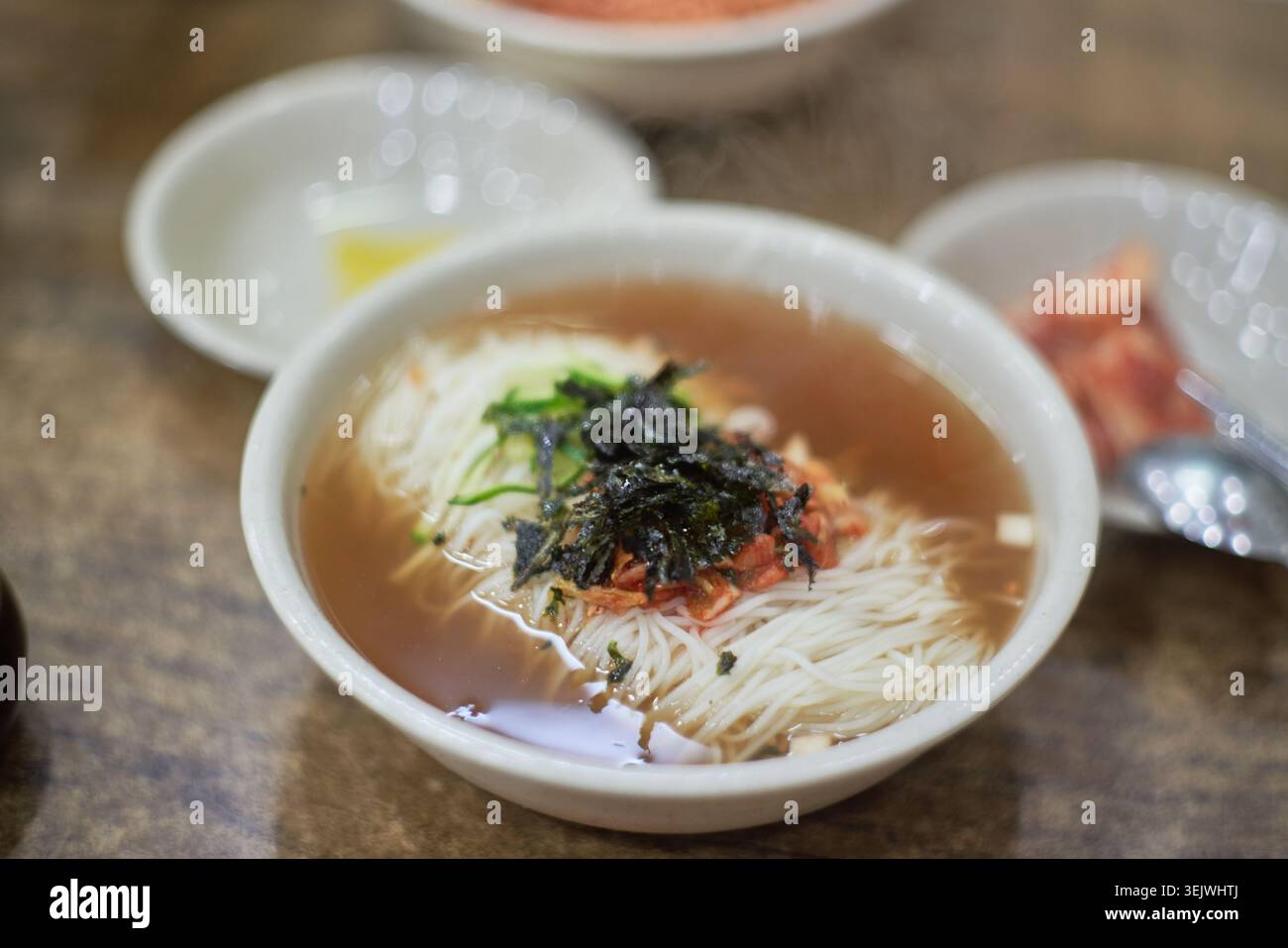 Janchi-guksu sert des nouilles chaudes dans un bouillon salé, contrastant avec le bibim-guksu doux, épicé et froid. Les deux offrent des saveurs coréennes authentiques. Banque D'Images