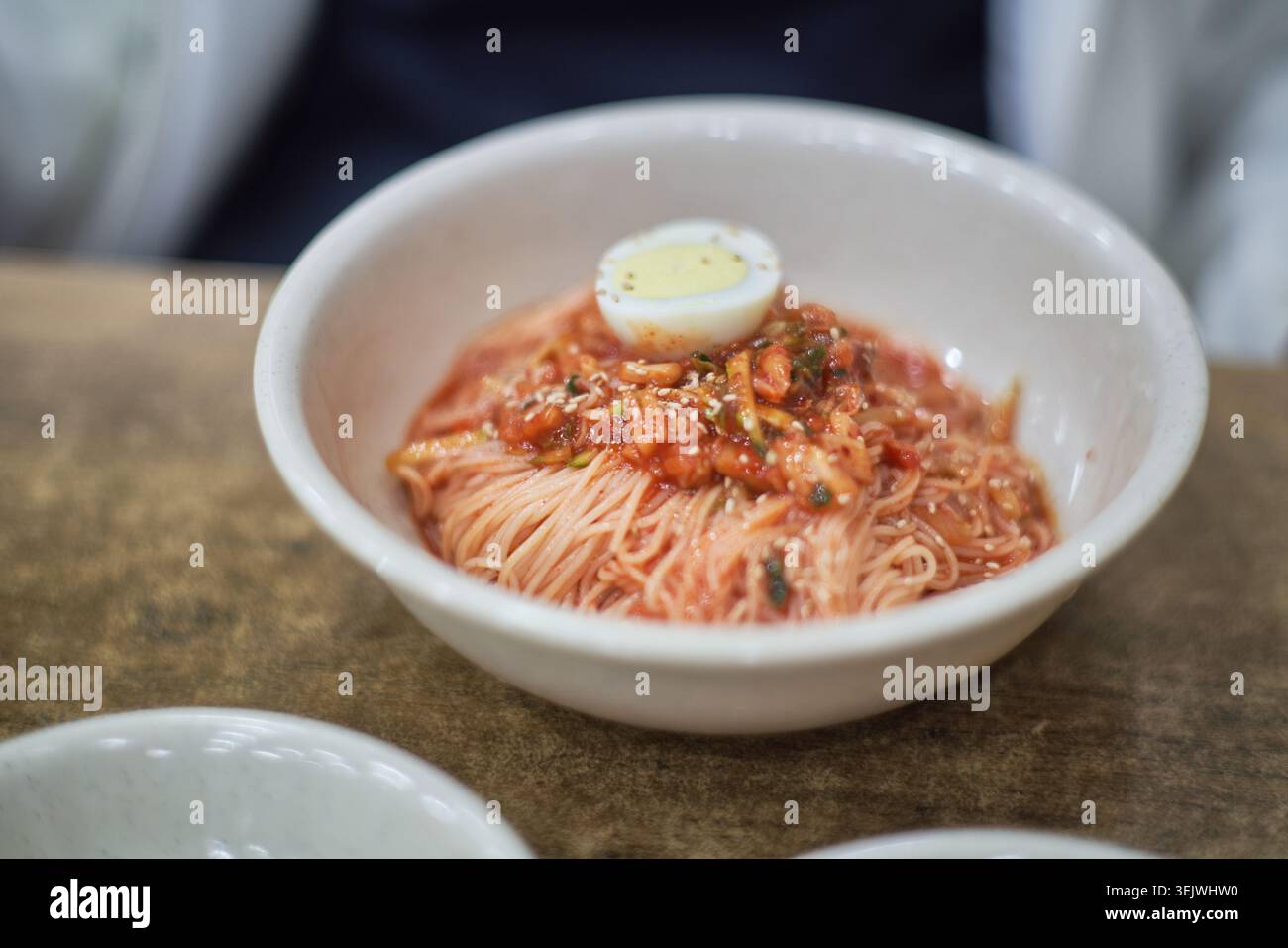 Janchi-guksu sert des nouilles chaudes dans un bouillon salé, contrastant avec le bibim-guksu doux, épicé et froid. Les deux offrent des saveurs coréennes authentiques. Banque D'Images